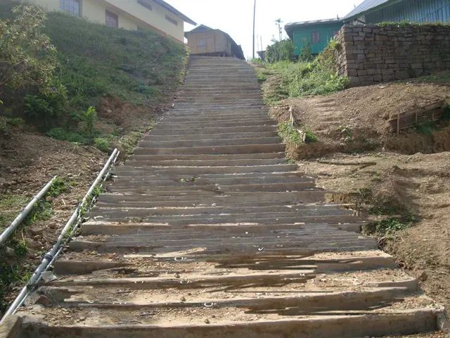 A paved footpath leading from a playground to the community hall at Longmisa