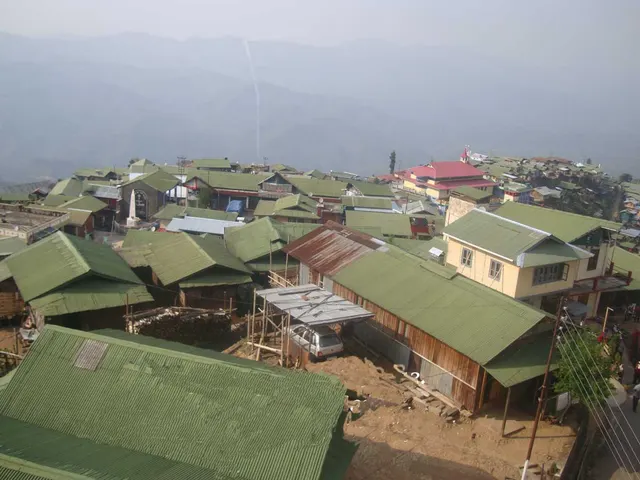 Workers painting the roof of a building at Longsa village